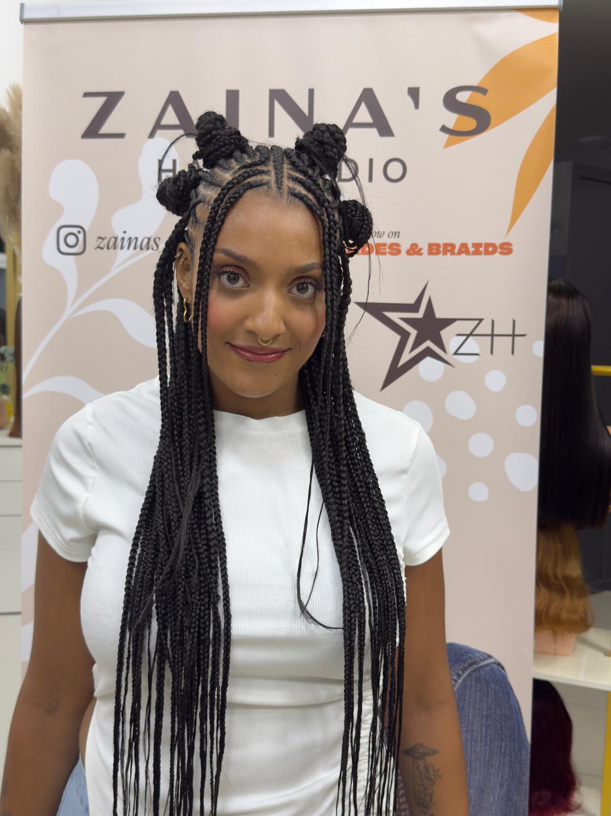 Space buns with long box braids styled at Zaina’s Hair Studio